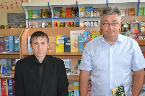 Дмитро Снегирьов (права) з відвідувачем книгарні